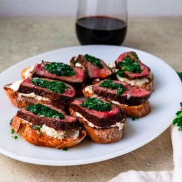Steak crostini with creamy boursin cheese and herb oil.