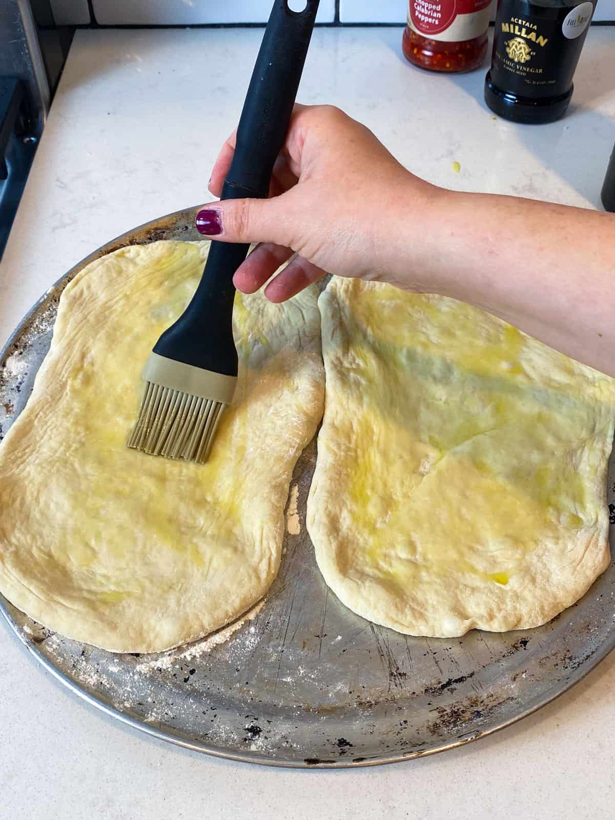 Brush the pizza dough with olive oil. This will prevent the dough from sticking when it's folded over.