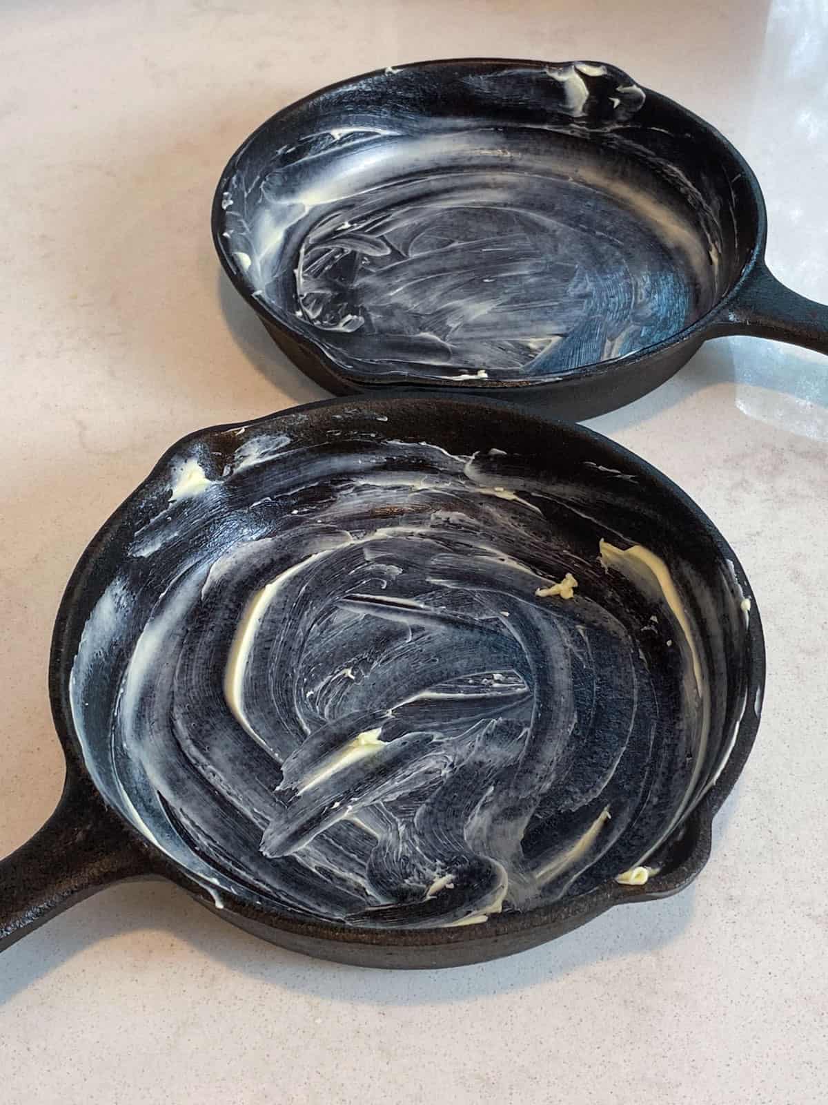 Butter the cast iron skillets all over with softened butter.