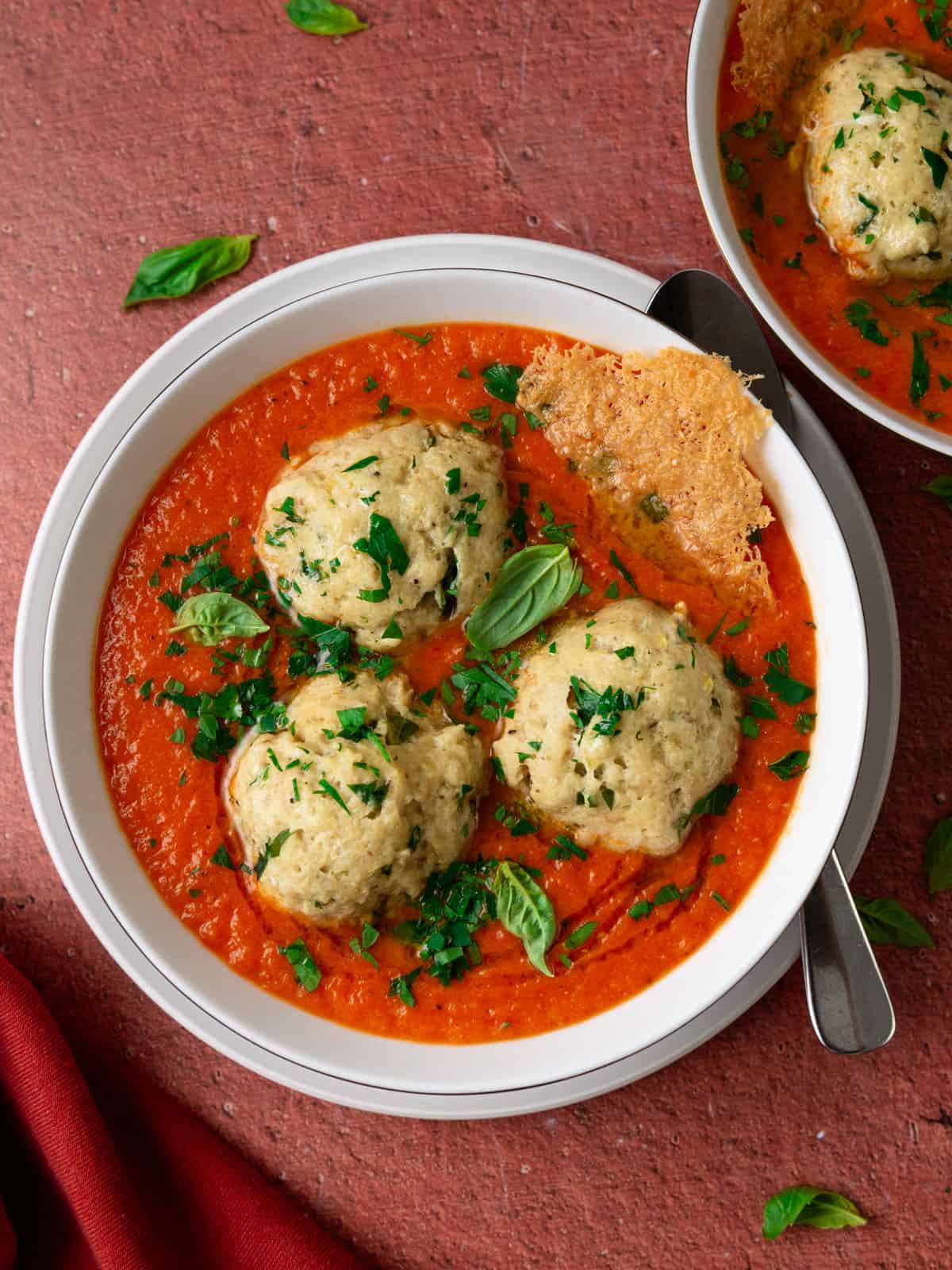 Cheesy matzo balls in roasted tomato soup with basil and Parmesan.
