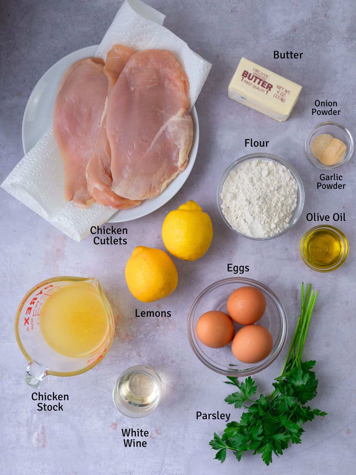 Ingredients for chicken francese, including fresh lemon, eggs, chicken stock and white wine.