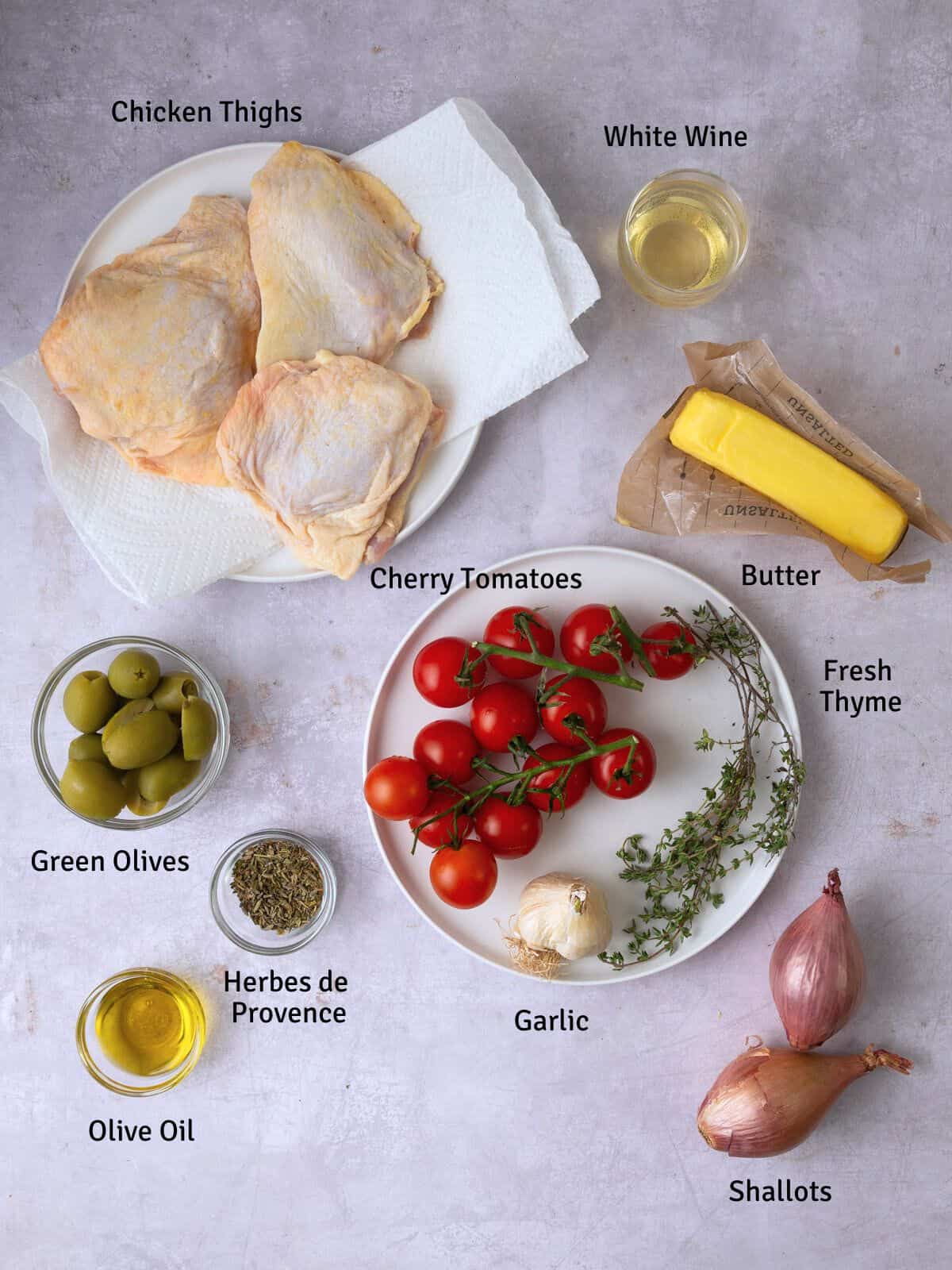 Ingredients for chicken Provencal, including white wine, green olives, shallots and tomatoes.