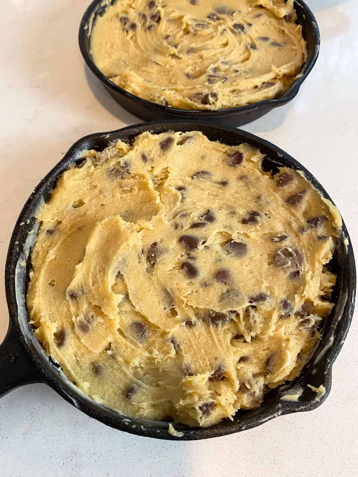 Divide the cookie dough between the two small cast iron skillets and spread the dough evenly into the skillet.