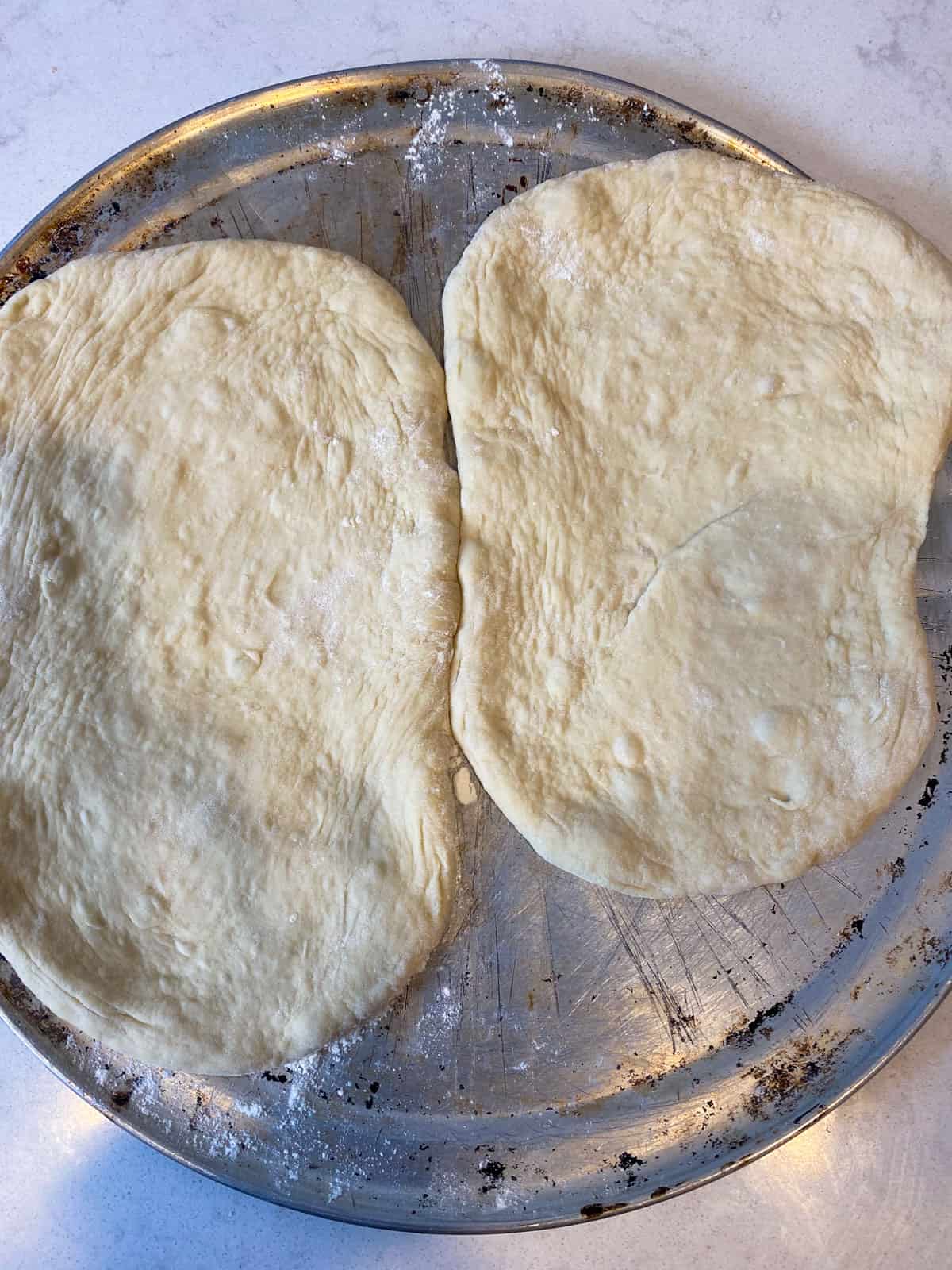 Stretch out both halves of the pizza dough into an oblong shape.