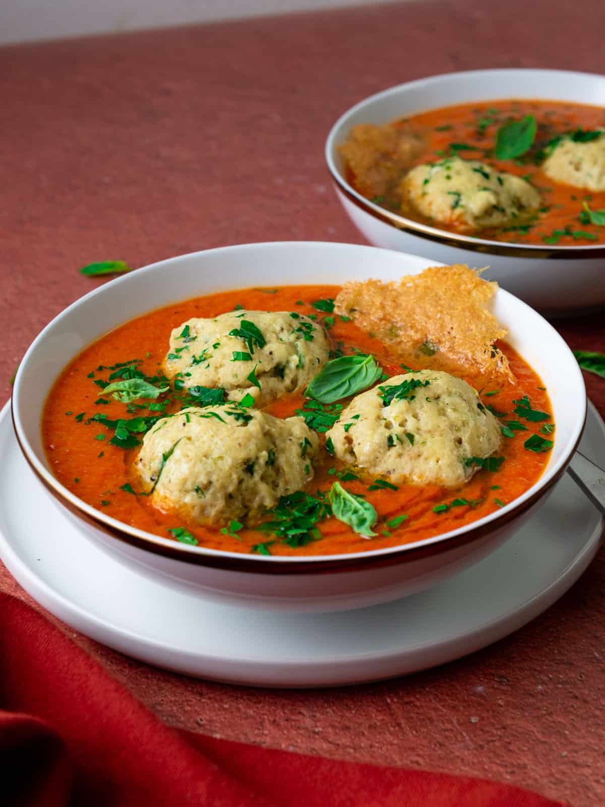 Roasted tomato soup with ricotta matzo balls and garnished with a parmesan crisp.