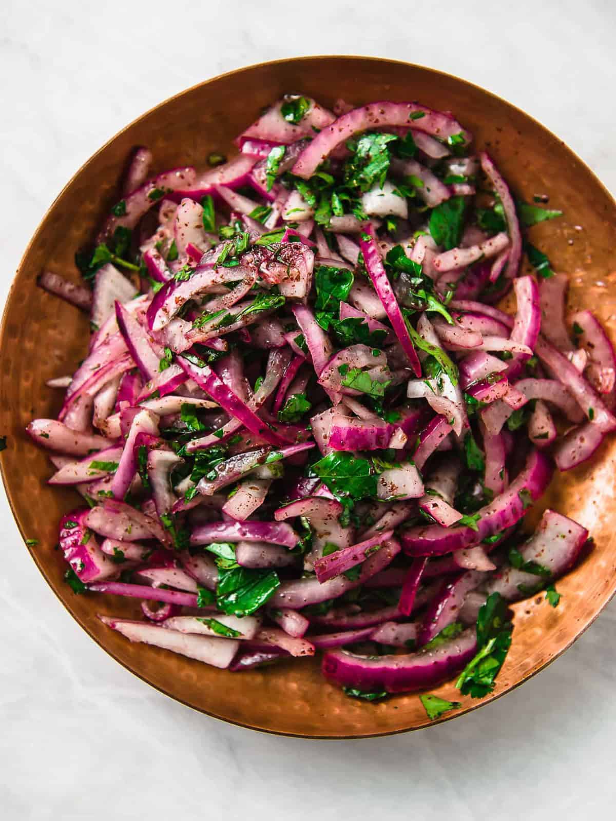 Turkish sumac onion salad has thinly sliced red onions tossed with bright sumac, fresh parsley and fresh lemon juice.