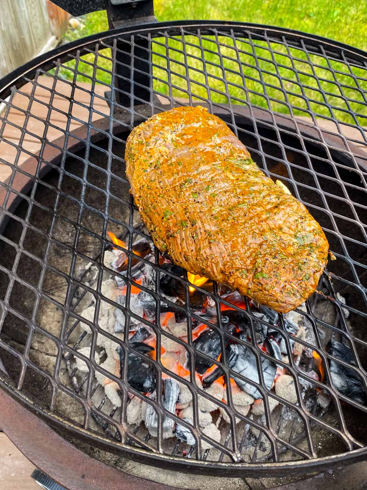 Place the marinated flank steak on a medium-hot grill.