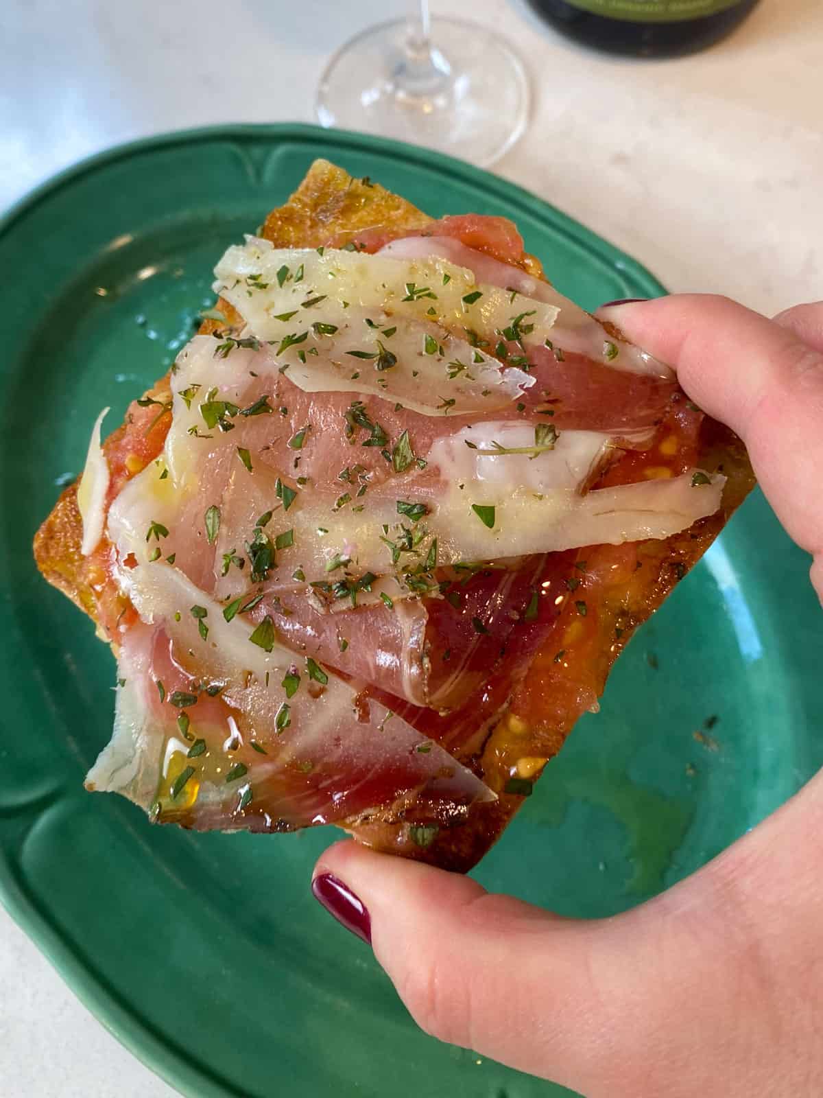 Layer a slice of manchego and jamón onto the tomato bread.