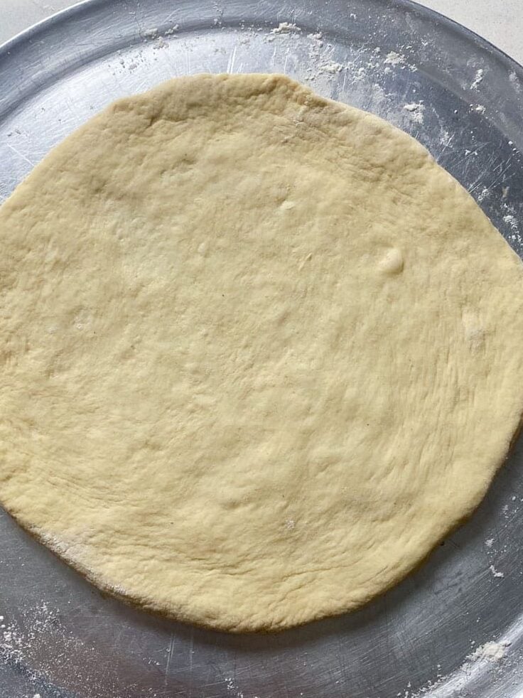 On a lightly floured surface,, roll out the pizza dough to a 9 to 10 inch circle.