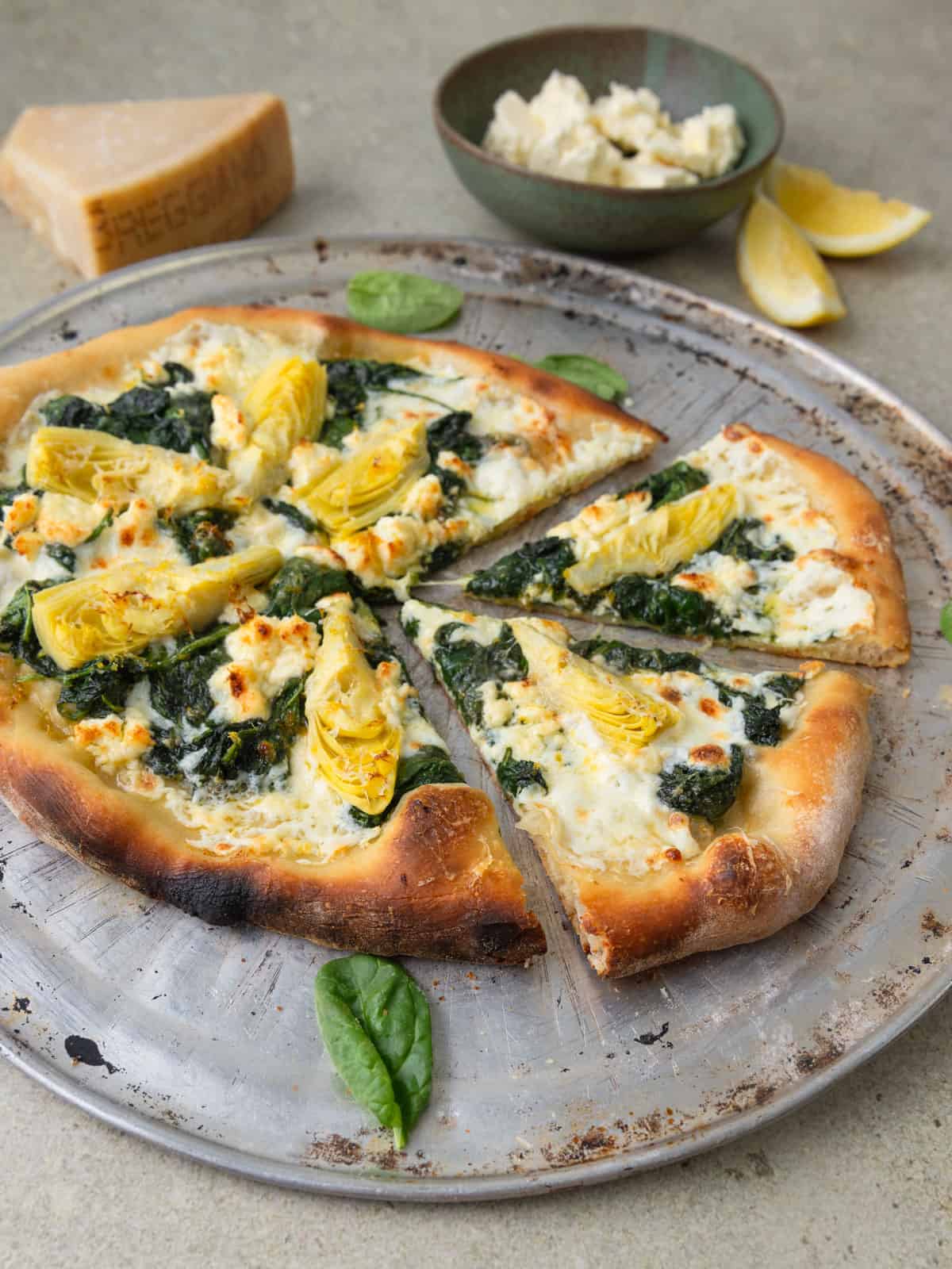 Spinach feta pizza with artichokes and Parmesan cheese.