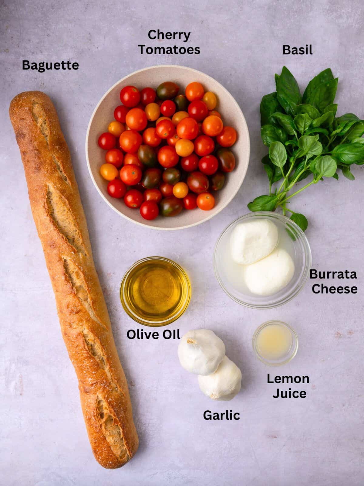 Ingredients for tomato and garlic confit, including burrata cheese, basil and olive oil.