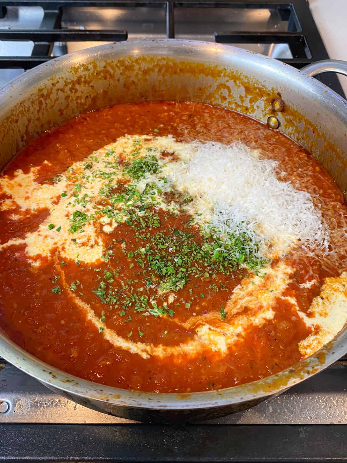 Add heavy cream and fresh oregano to the tomato sauce.