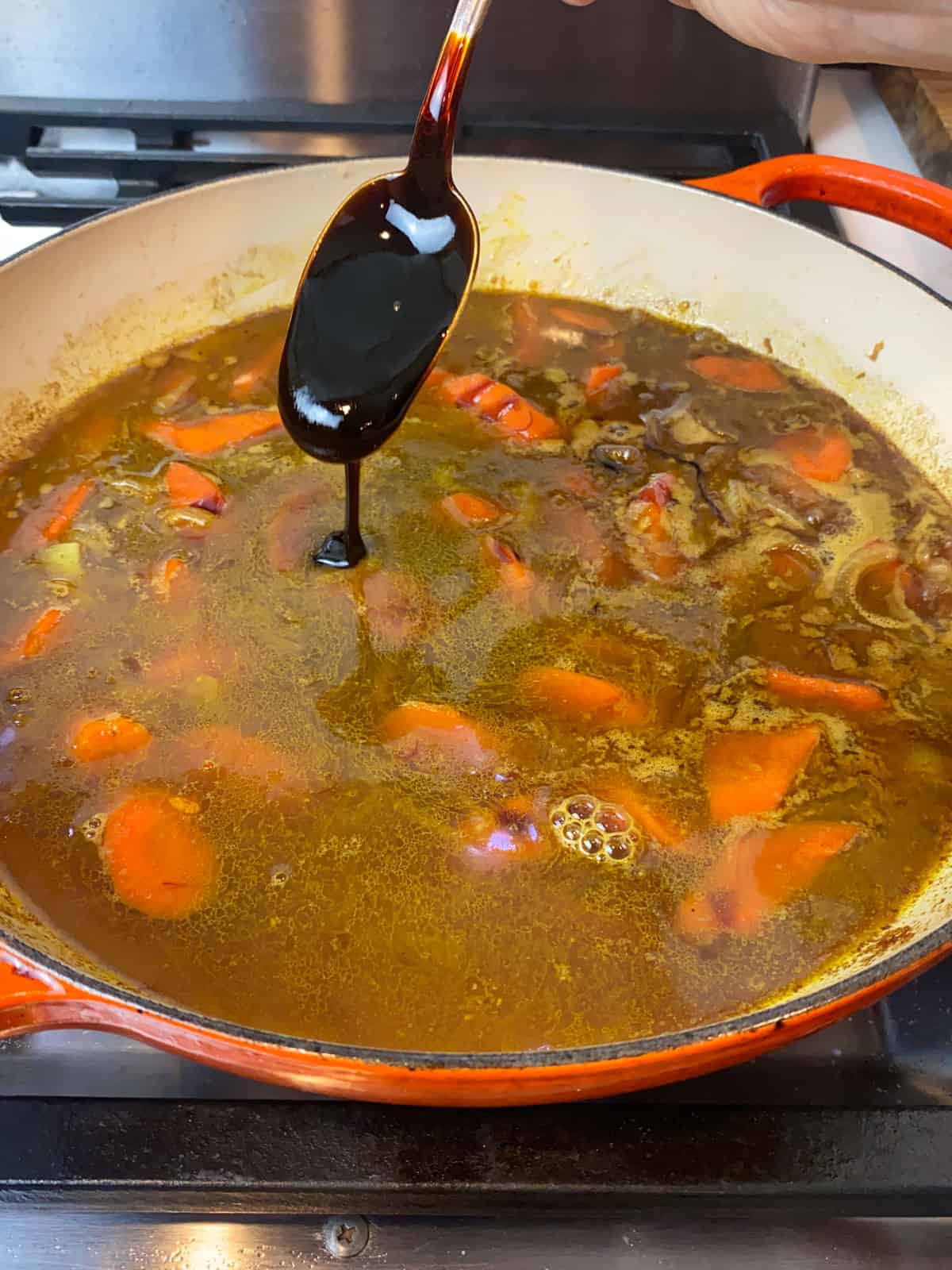 Add date molasses to the chicken stock and red wine mixture.