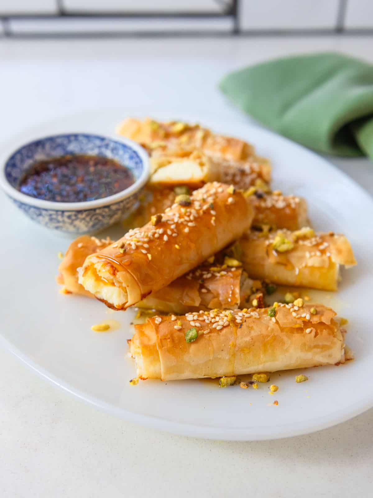 Feta rolls wrapped in phyllo and served alongside spicy honey for dipping.