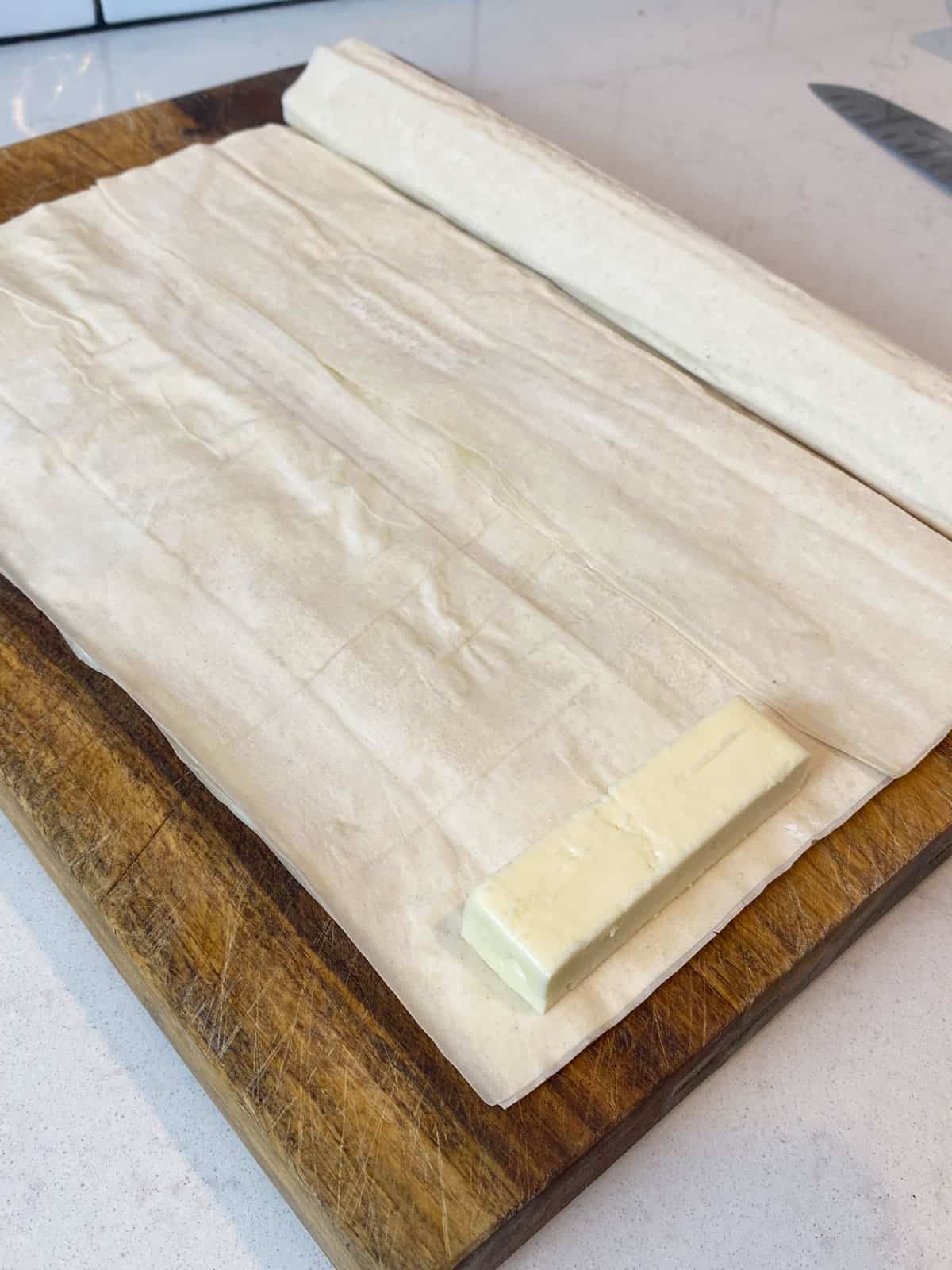 Place a rectangle shaped piece of feta onto the phyllo and cut alongside, leaving a ½ inch border on each side.