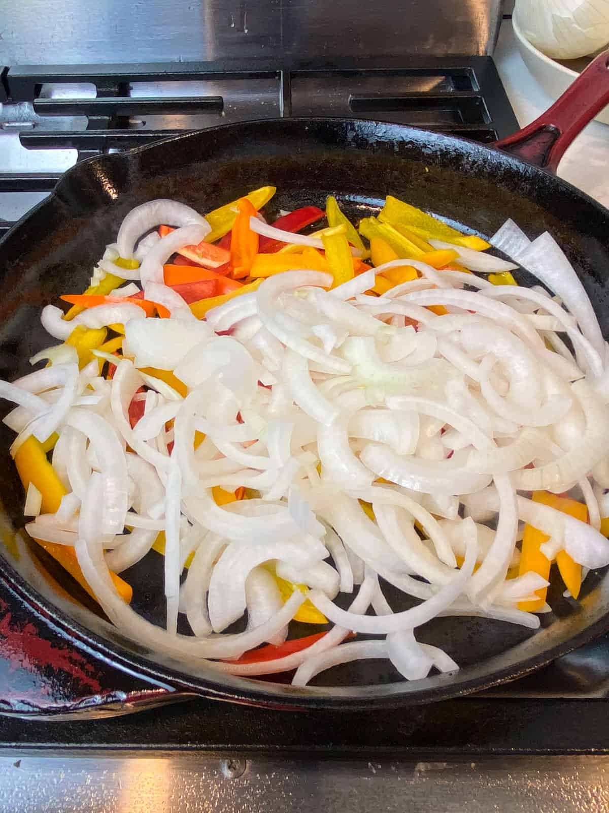 Saute the sliced bell peppers and onions in a cast iron skillet.