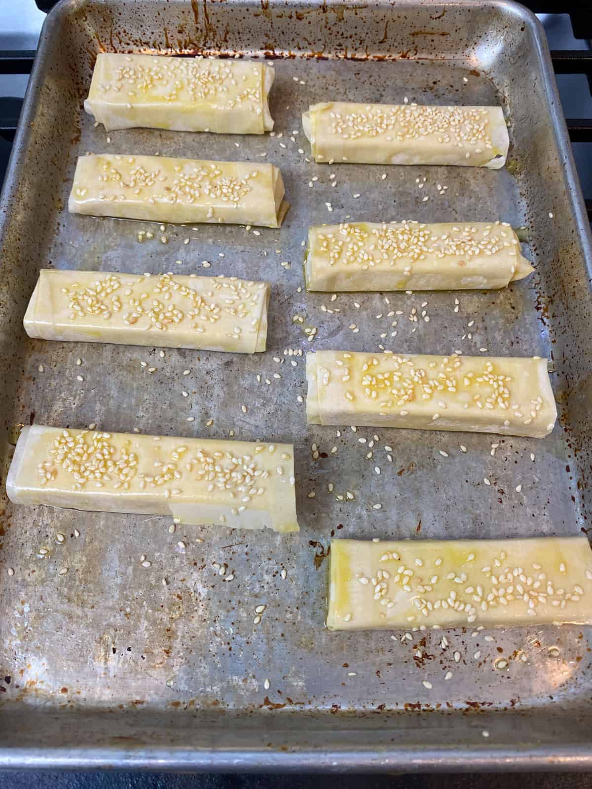 Sprinkle sesame seeds onto the feta rolls before baking.