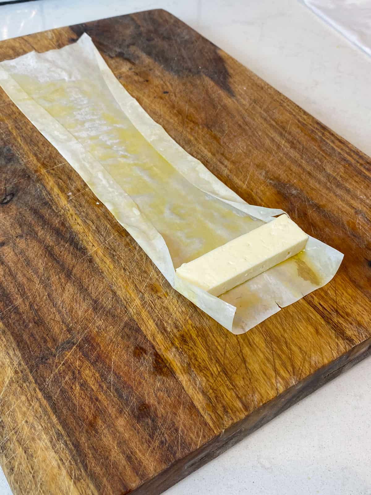 Place the rectangle shaped feta cheese onto the oiled phyllo sheet.