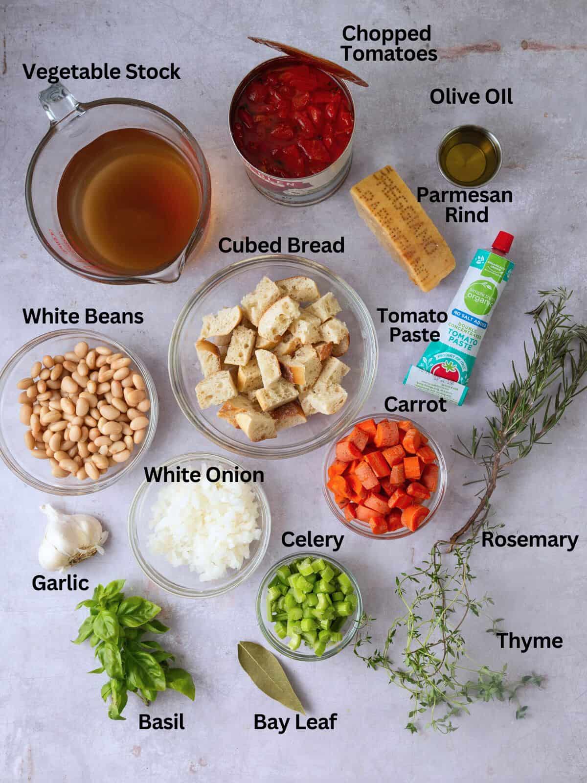 Ingredients for Tuscan bread soup, including cubed bread, white beans, herbs and Parmesan.