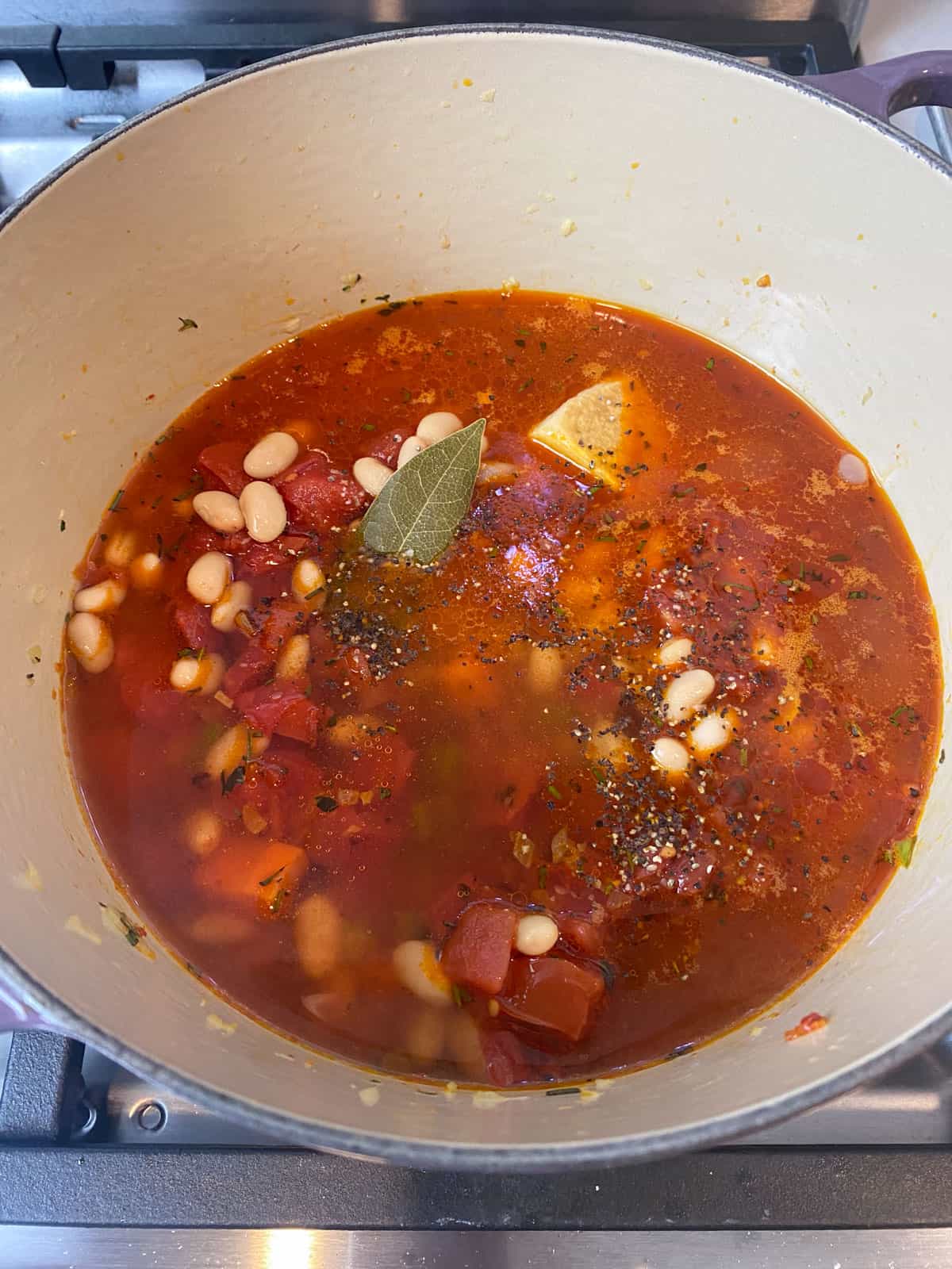 Add the vegetable stock, bay leaf and parm rind to the Italian tomato soup.