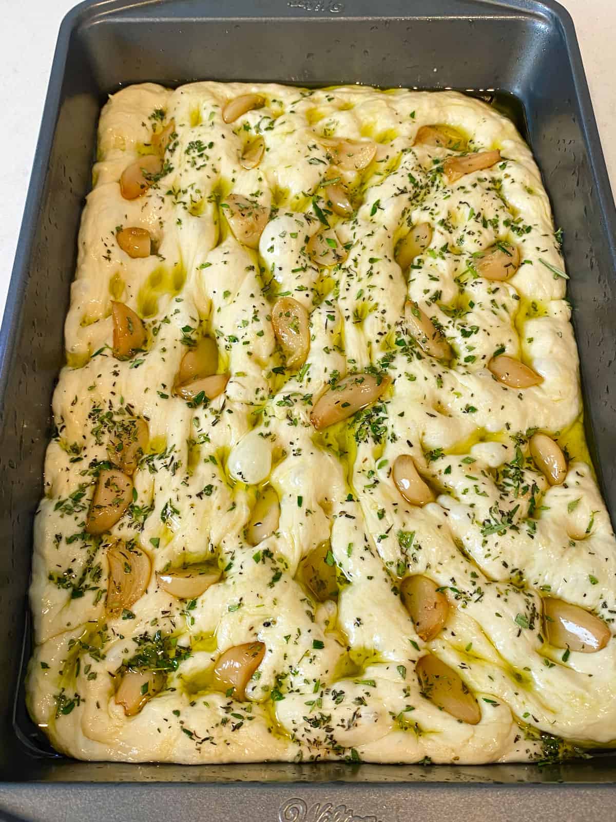 Add the roasted garlic cloves and fresh herbs to the focaccia dough.