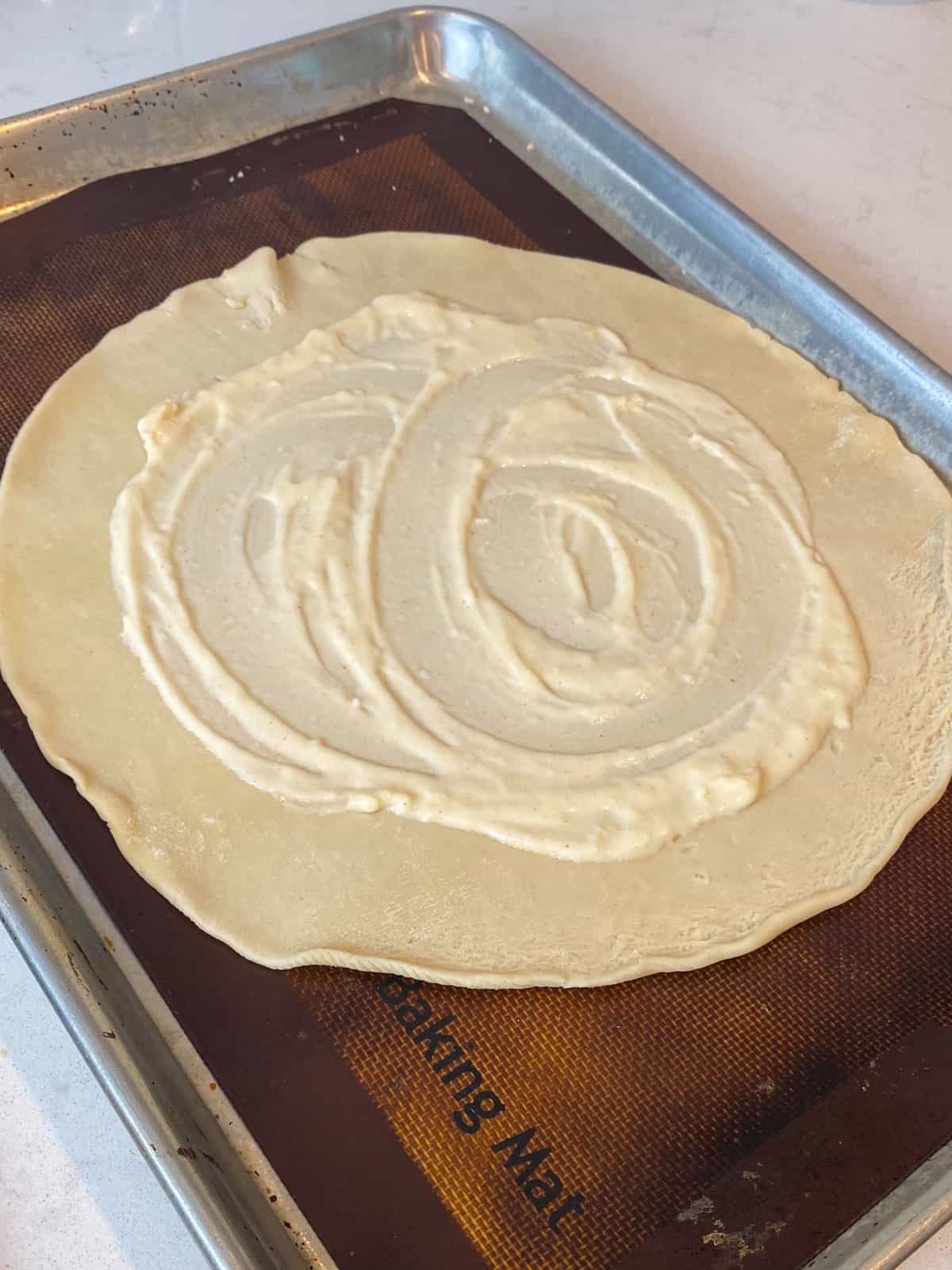 Spread a thin layer of bechamel onto the pie dough.