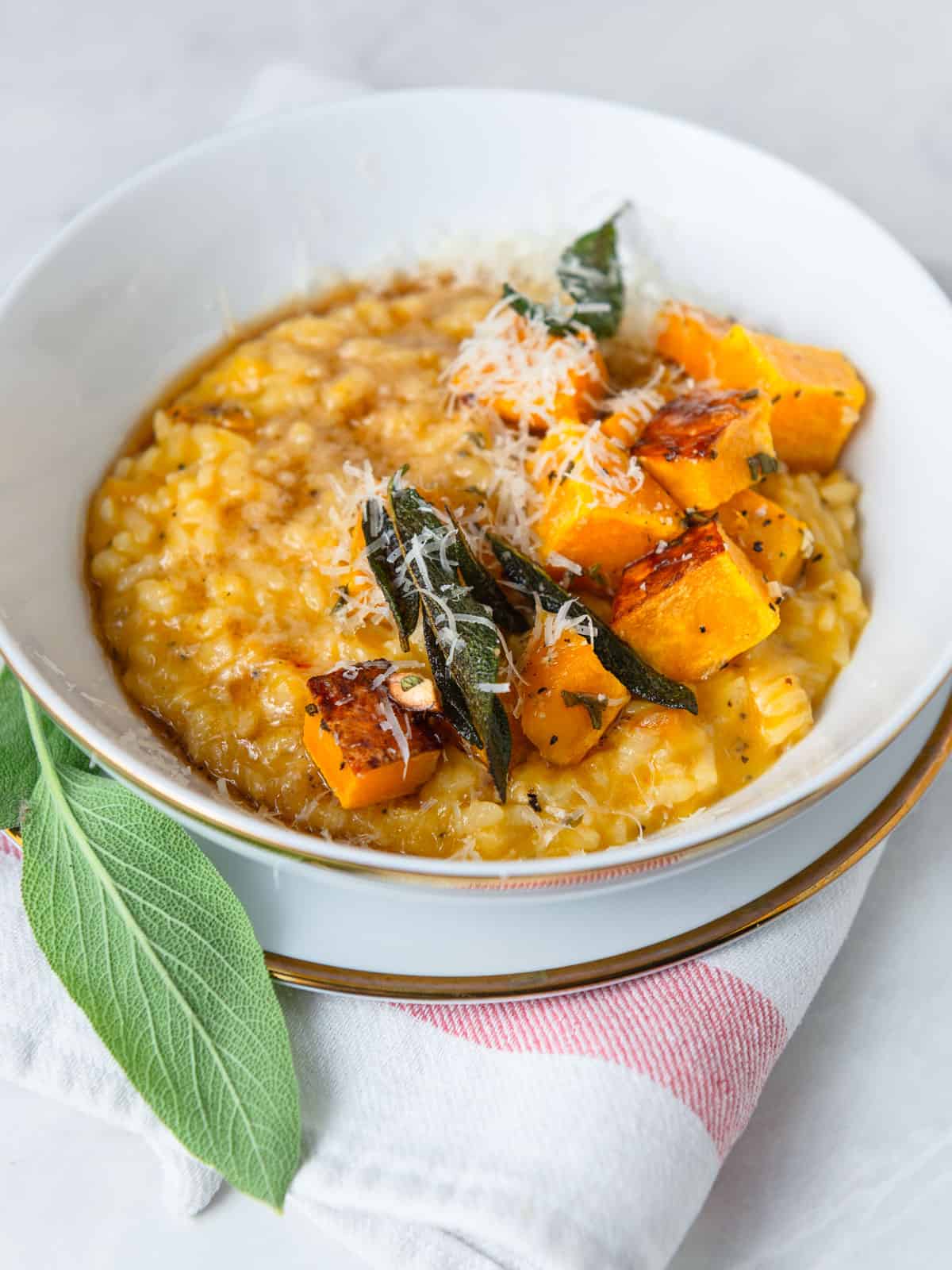 Creamy butternut squash risotto topped with roasted butternut squash and fried sage.