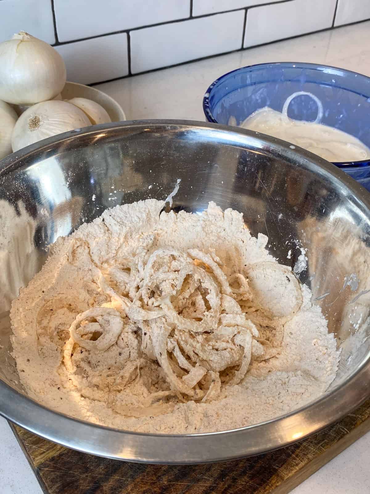 Dredge the buttermilk onions in the seasoned flour mixture.