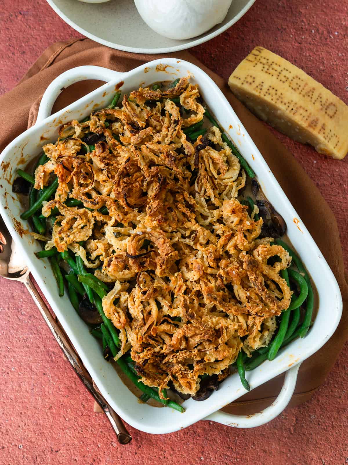 Homemade green bean casserole with fried onions and Parmesan cheese.