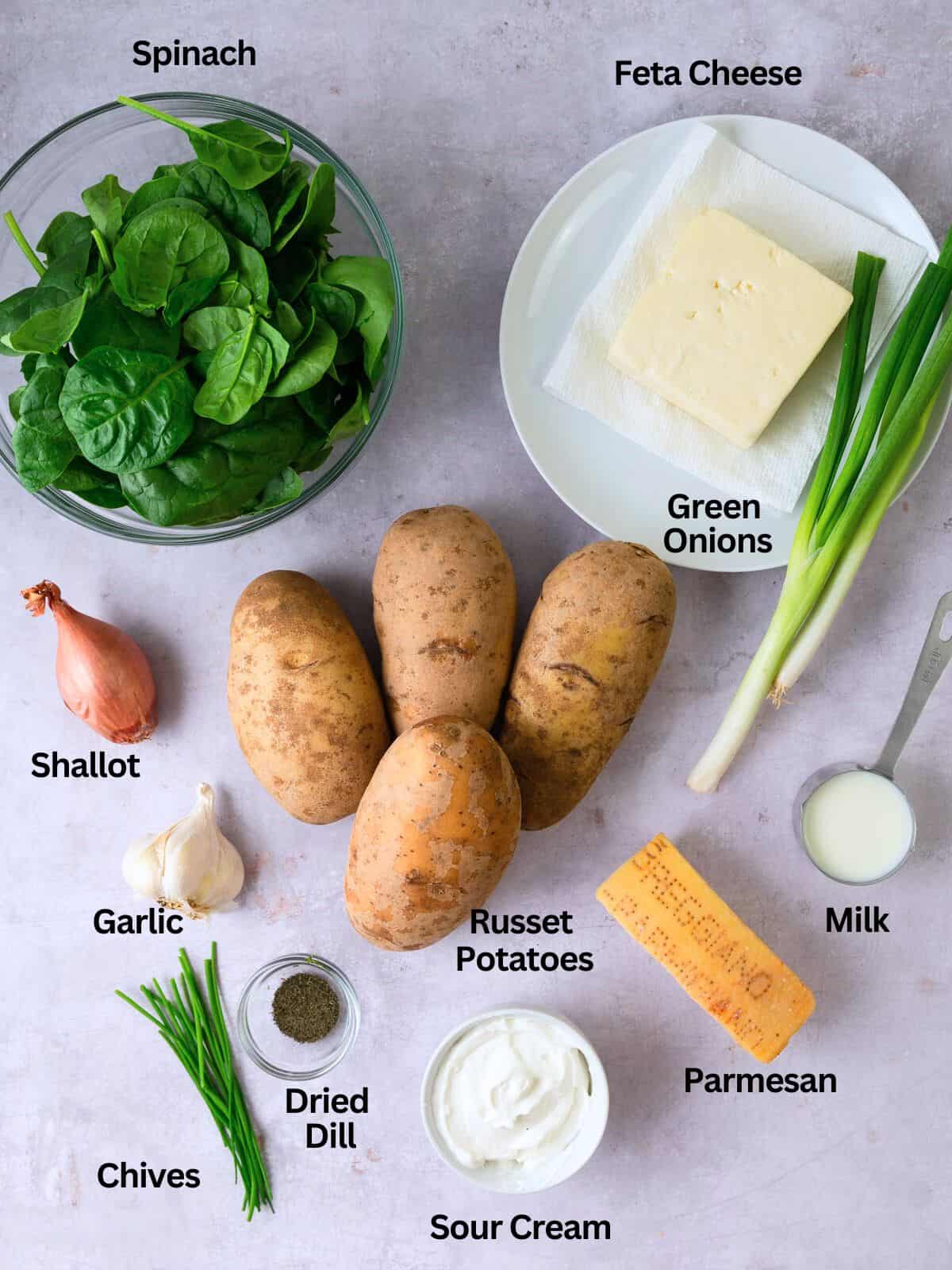 Ingredients for spinach and feta baked potatoes, including Parmesan cheese, sour cream and garlic.