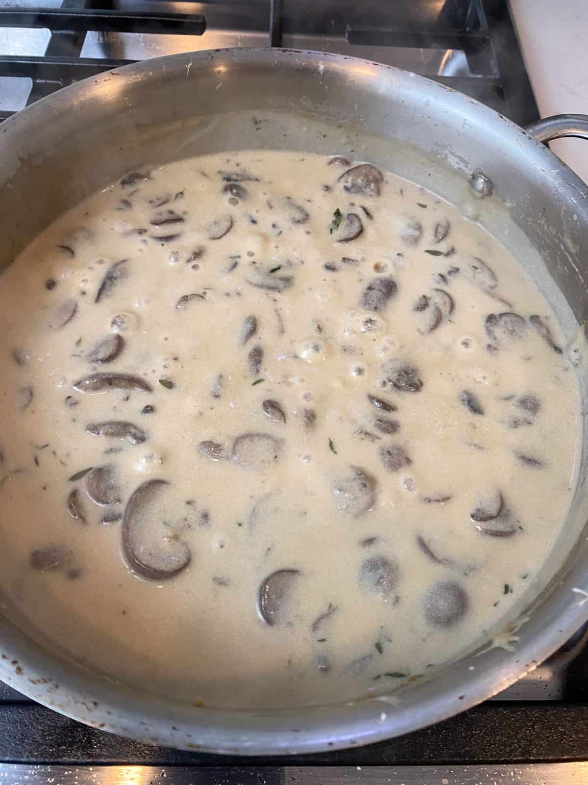 Simmer the creamy mushroom mixture until slightly thickened.