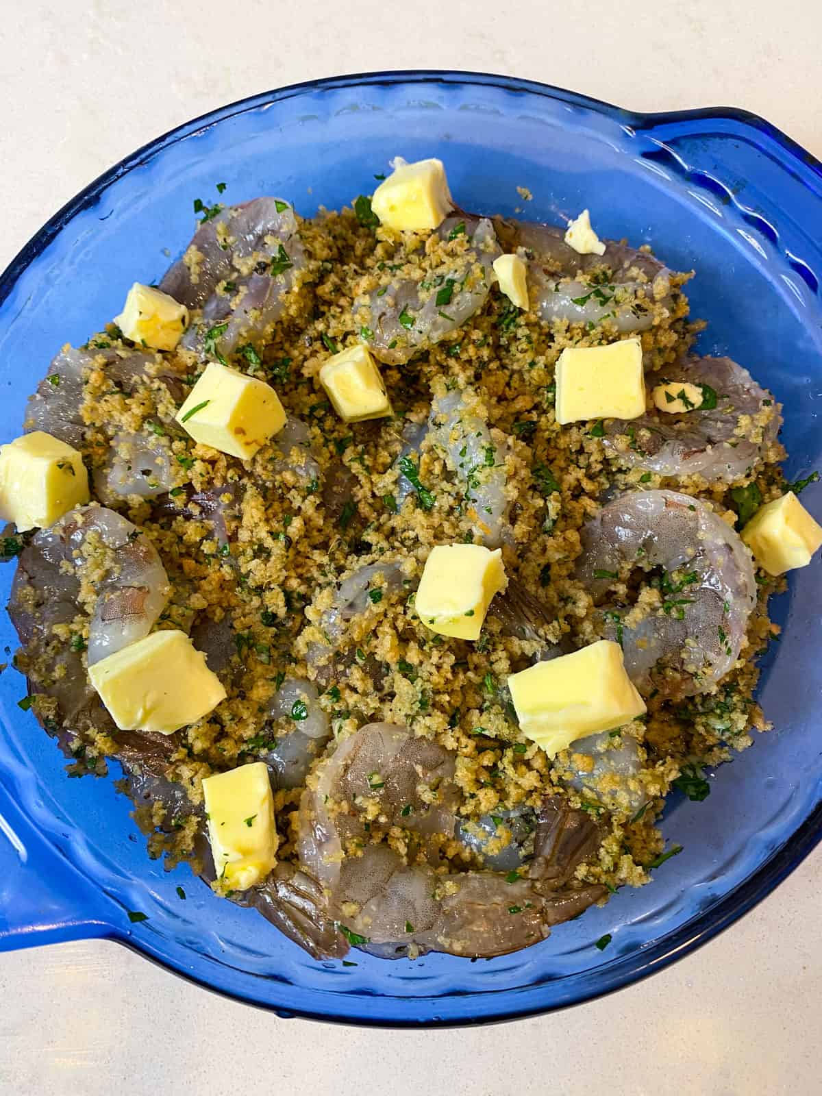 Stuff the butterflied shrimp with the breadcrumb mixture and top with cubes of butter.