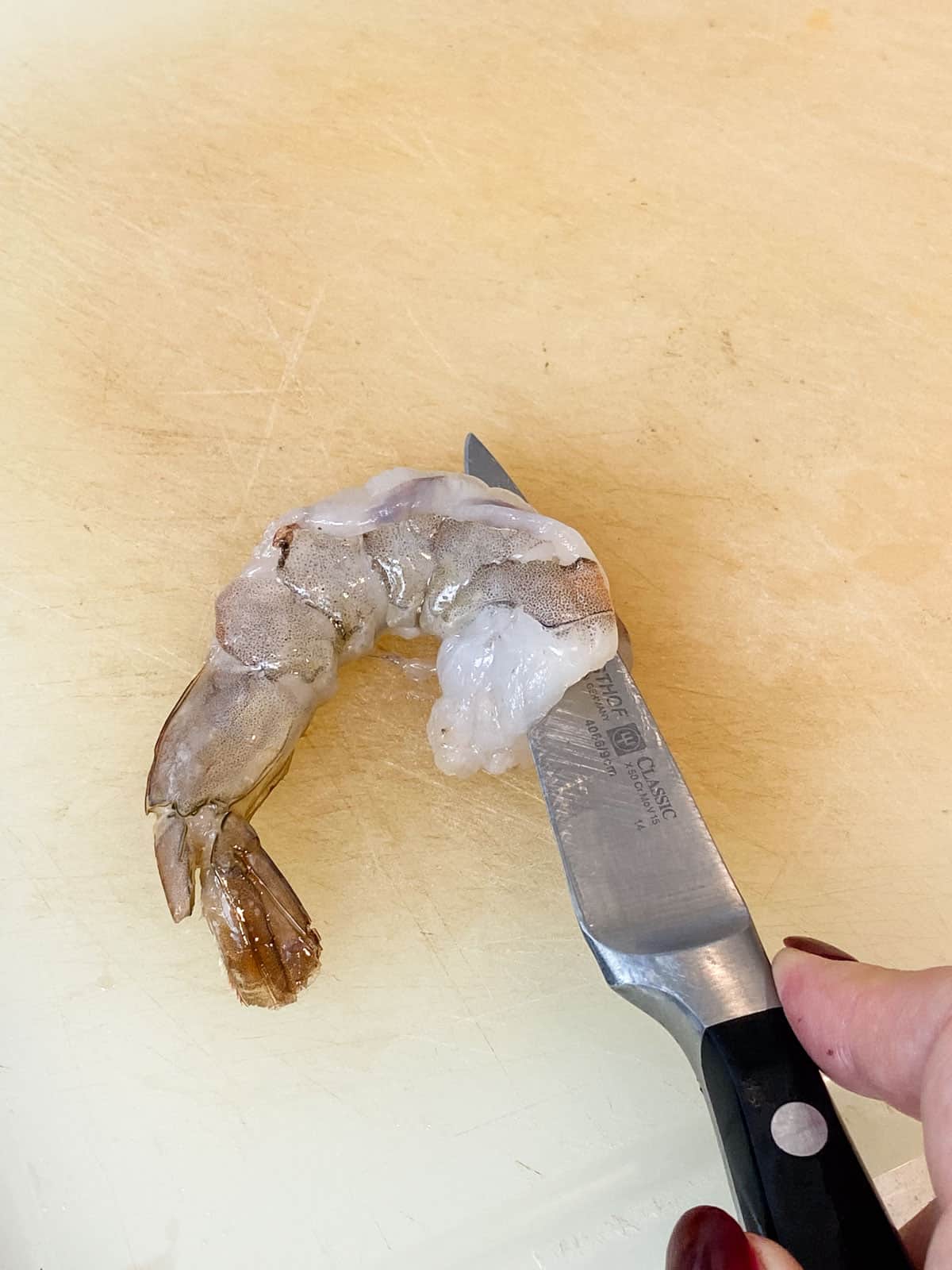 Cut the tail of the shrimp in half, creating a butterflied shrimp.