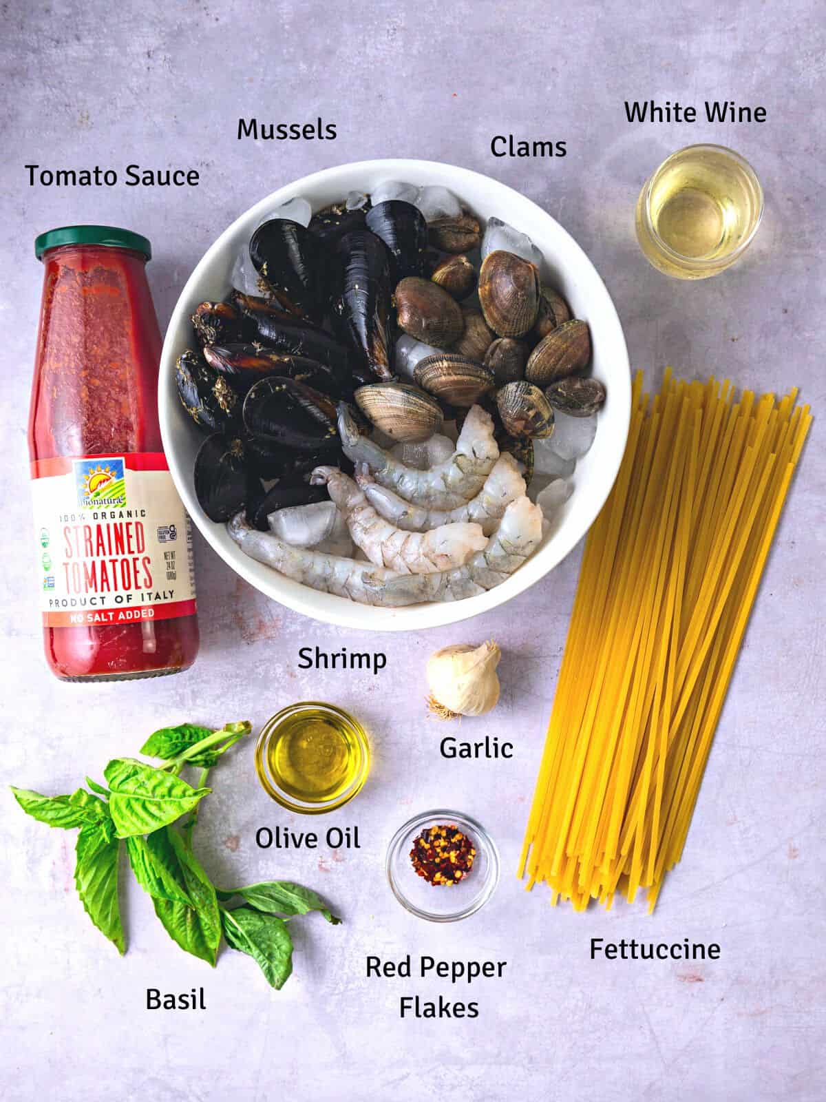 Ingredients for shellfish pasta including mussels, clams, shrimp and tomato sauce.