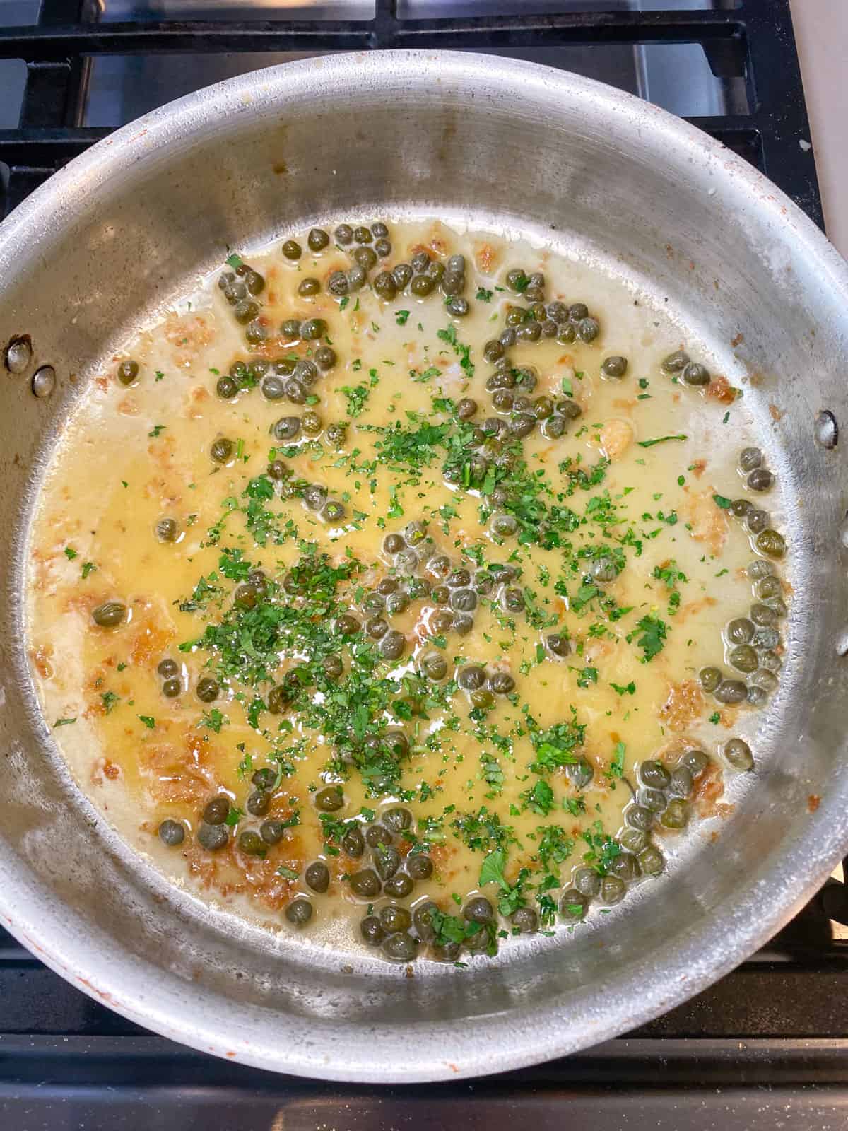 Add chopped parsley to the lemon butter caper sauce.