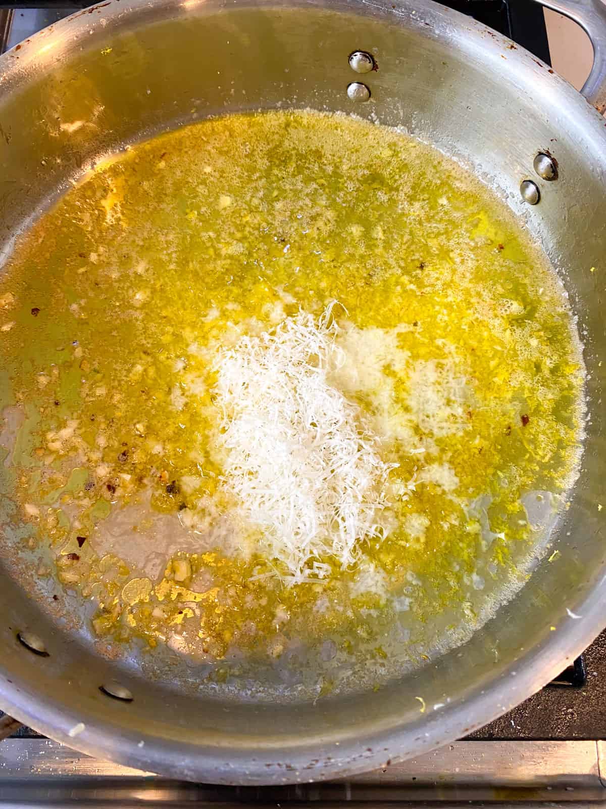 Add lemon zest, lemon juice and grated Parmesan cheese to the garlic butter sauce.