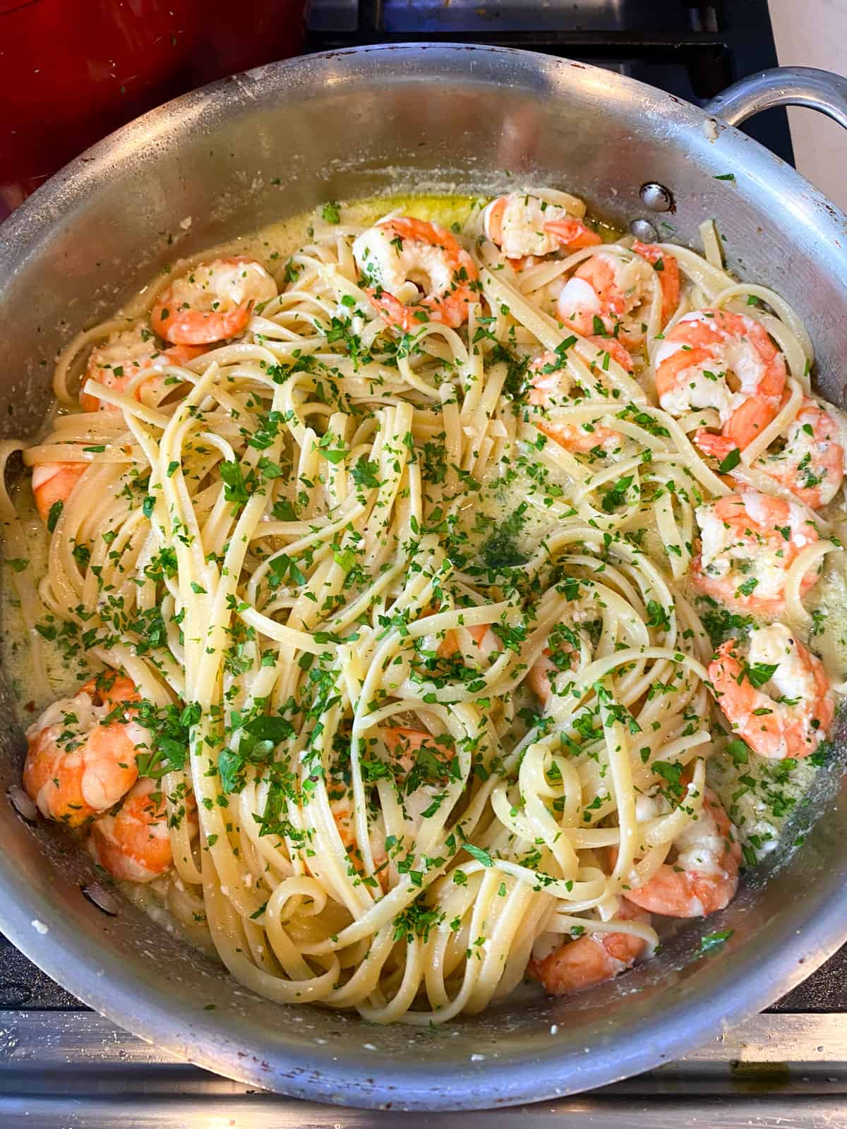 Add cooked linguini to shrimp scampi and toss to combine.