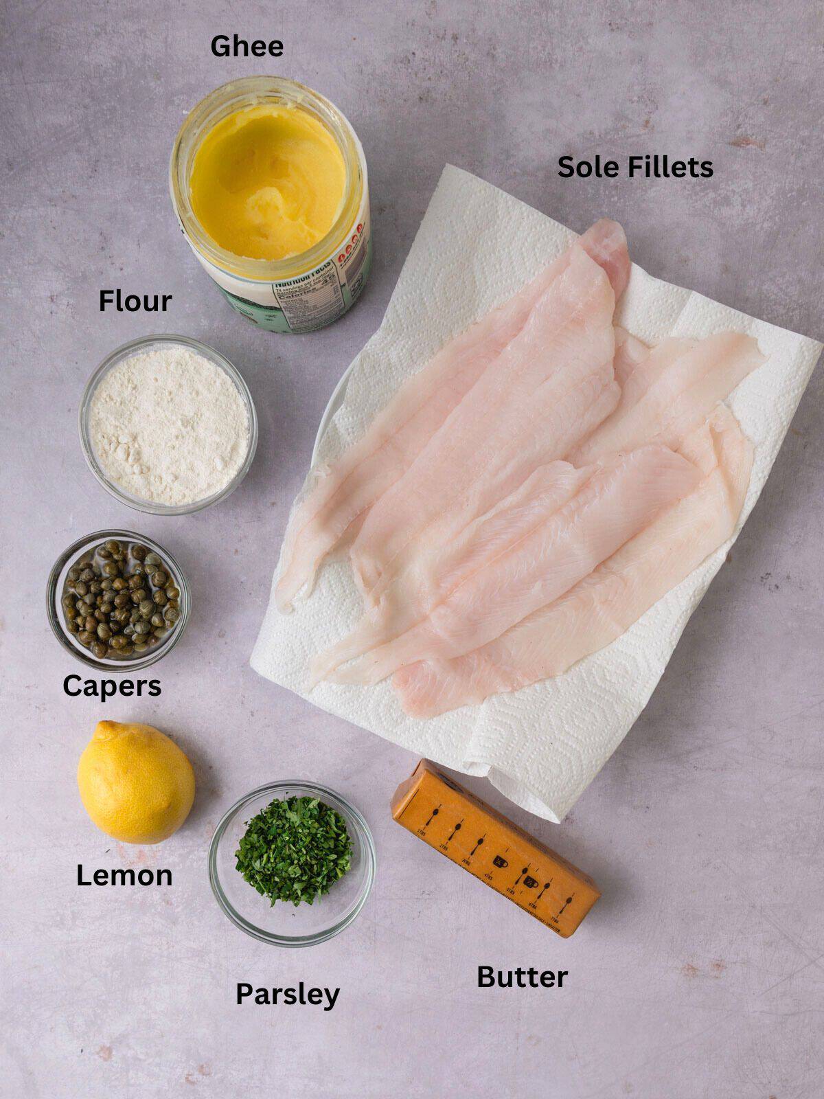 Ingredients for Julia Child's sole meuniere, including sole fillets, capers, lemon and butter.