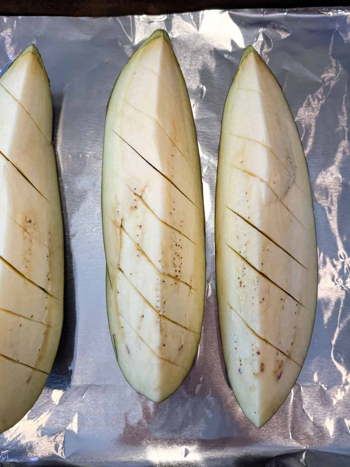 Cut slits into the flesh of the eggplant.