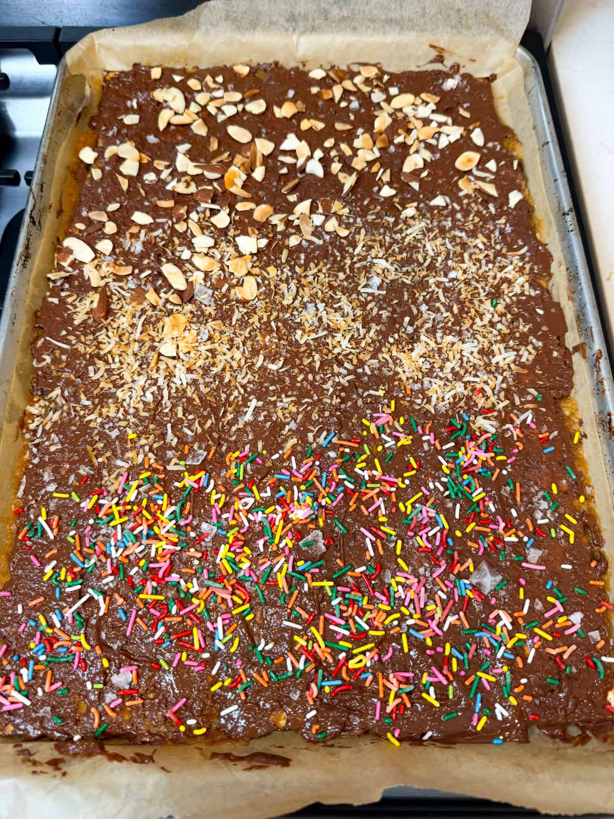 Sprinkle toppings onto the matzo toffee, such as sea salt, sprinkles, toasted almonds and toasted coconut.