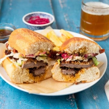 Beef milanesa sandwich layered with chimichurri and pickled onions.