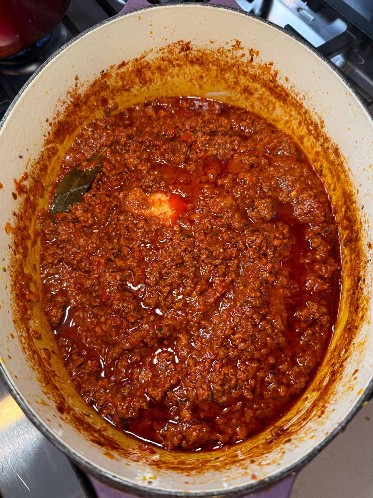 Cook the bolognese sauce util thickened and reduced.