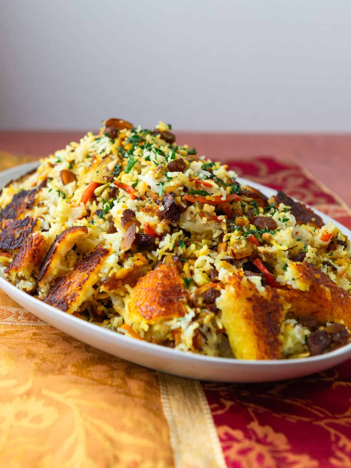 Persian jeweled rice with saffron tahdig and dried fruit.