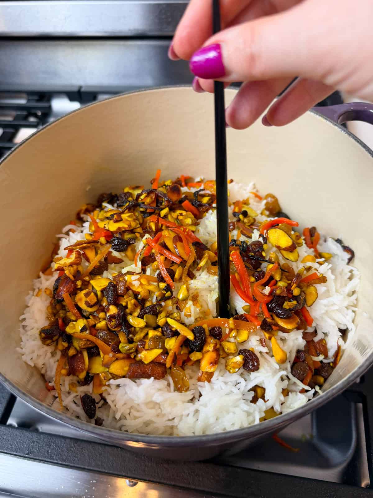 Use a stick to poke several holes into the jeweled rice so steam can escape.