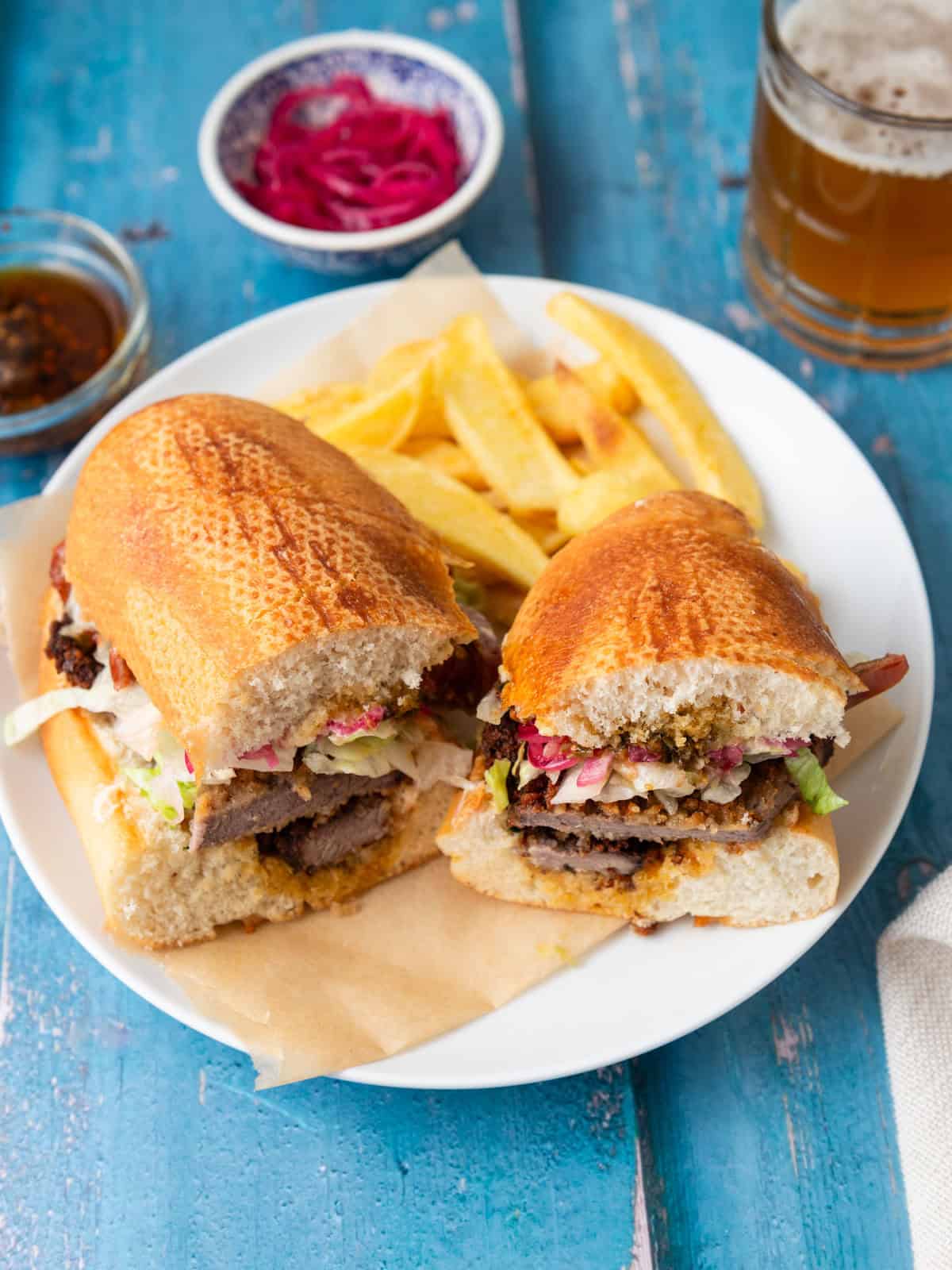 Steak milanesa sandwich with pickled onions and chimichurri.