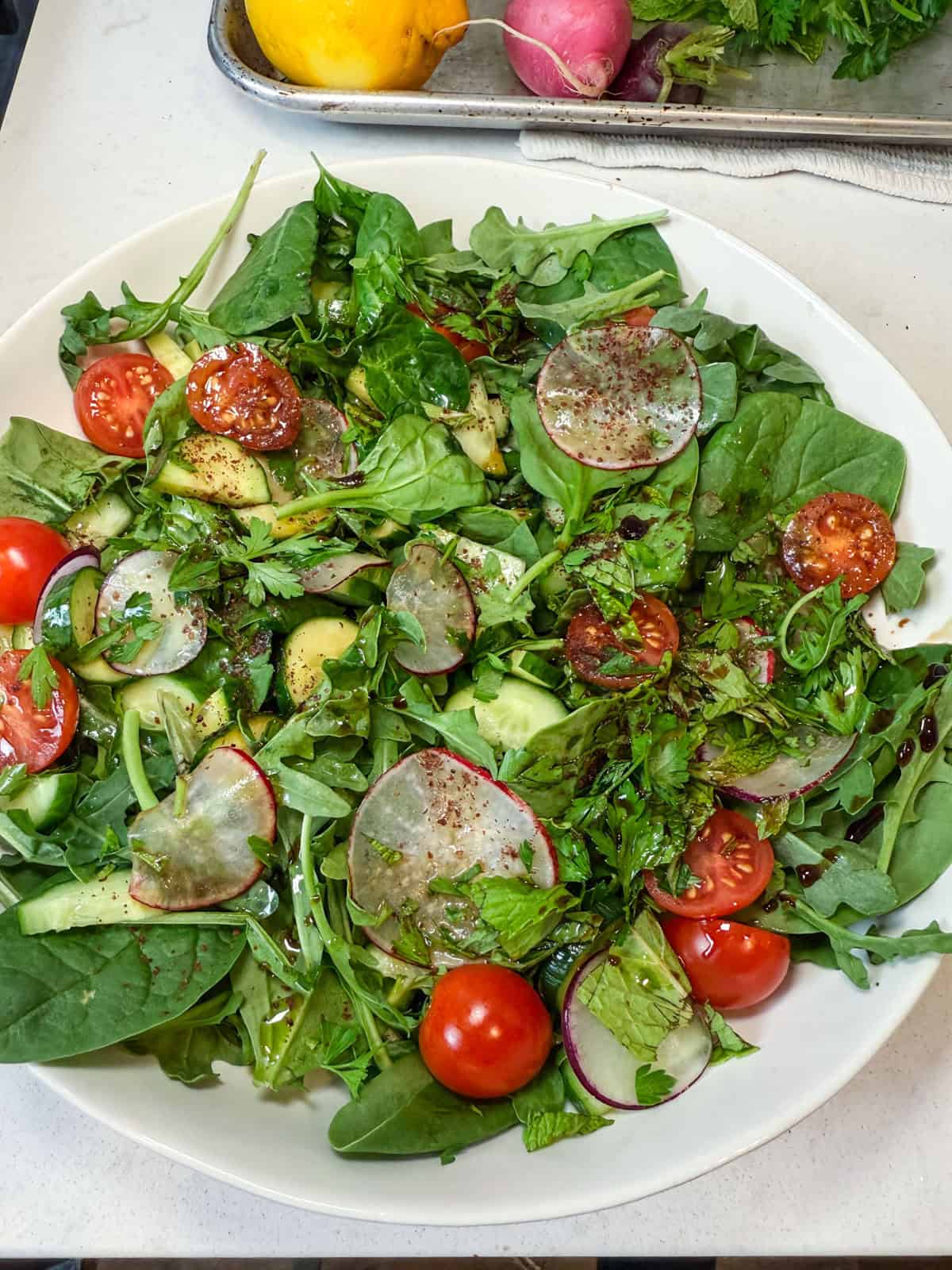 Assemble the salad for the salmon shawarma and mix together the salad greens, cucumbers, radish, cucumbers and tomatoes,