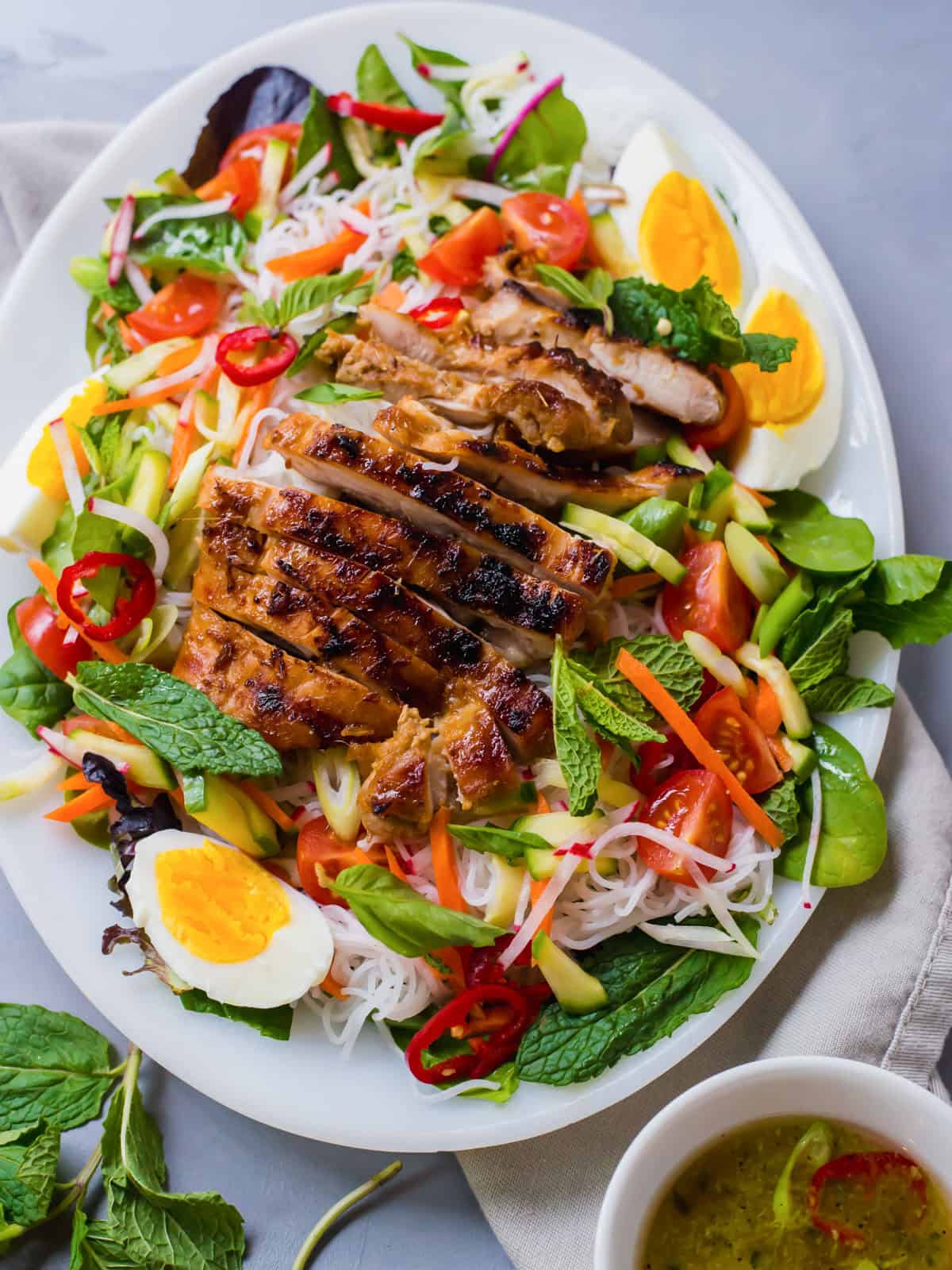 This cold rice noodle salad is layered with fresh herbs, tender mixed greens and a flavorful Vietnamese grilled chicken.