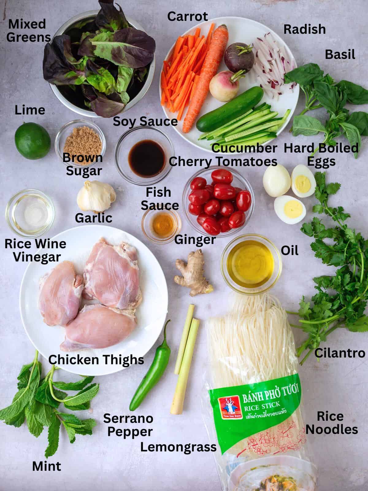 Ingredients for rice noodle salad, including fresh herbs, chicken thighs, hard boiled eggs and ingredients for the chicken marinade.