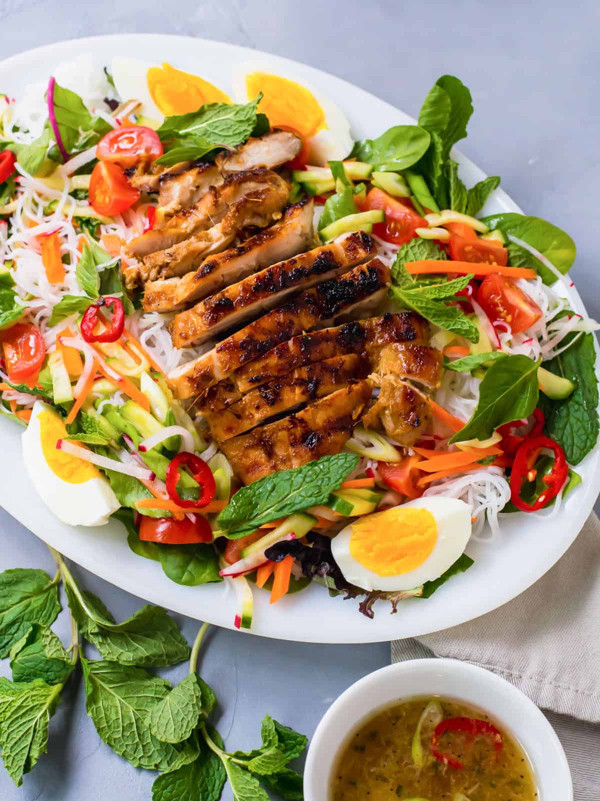 Rice noodle salad with tender greens, fresh herbs and topped with charred lemongrass chicken.