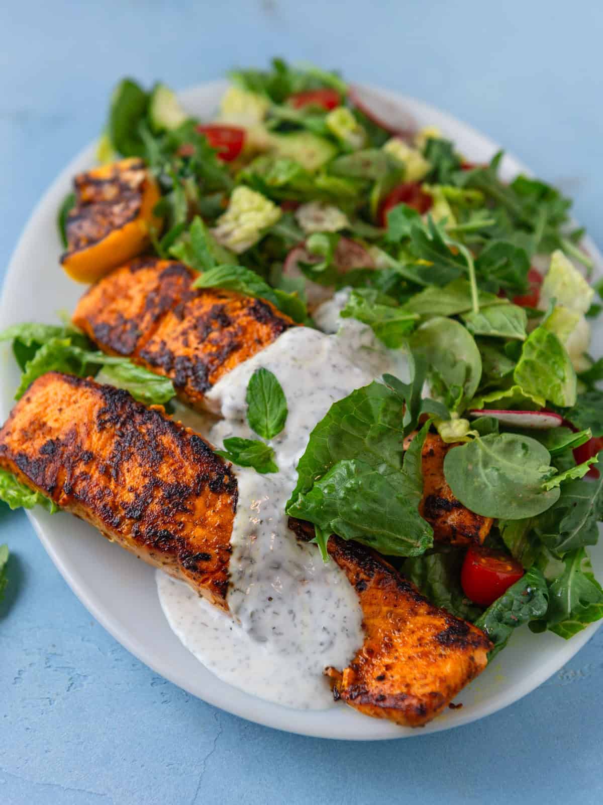 This recipe for salmon shawarma salad is full of bold flavors with a creamy yogurt sauce and fresh greens.